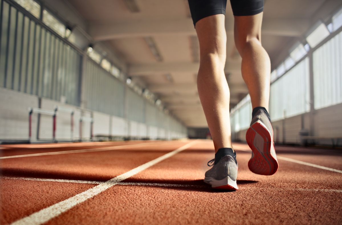 陸上トラックを走る選手の足元。足が地面につく瞬間